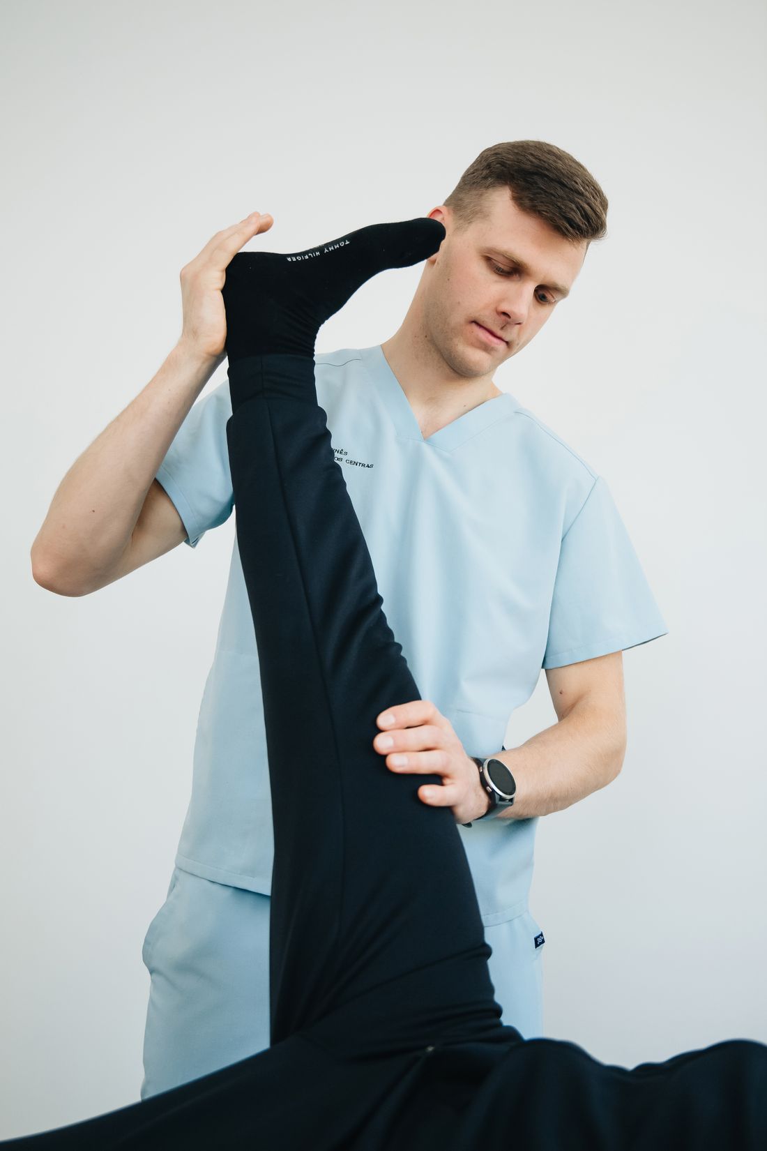 Fisioterapeuta realizando terapia manual segurando a perna do paciente
