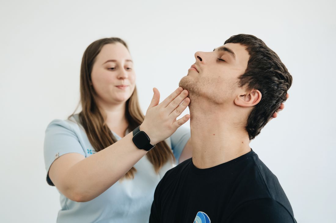 Fisioterapeuta trabalhando o pescoco e a mandibula do paciente