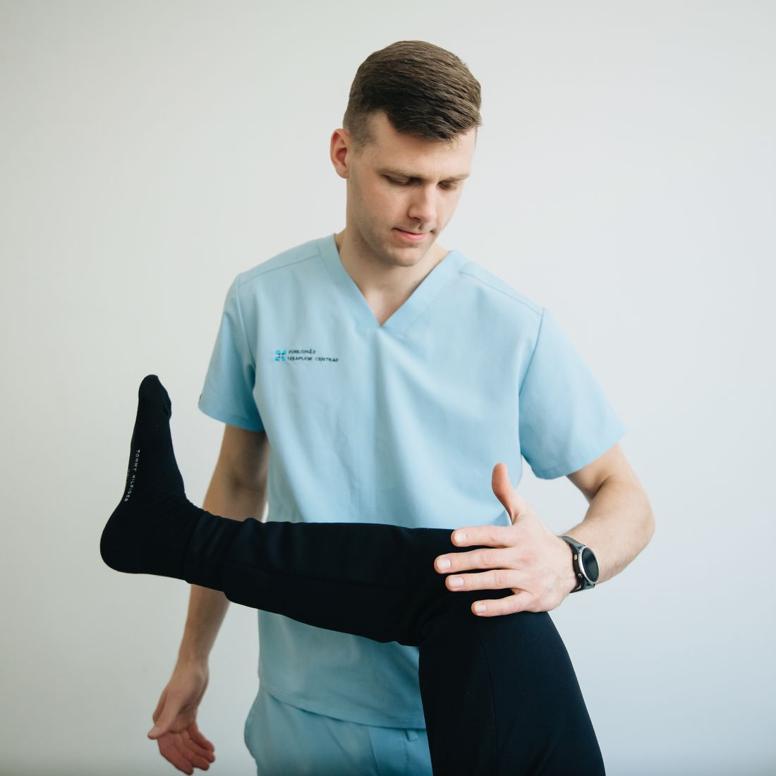 Fisioterapia do joelho: fisioterapeuta segurando o joelho do paciente durante avaliacao