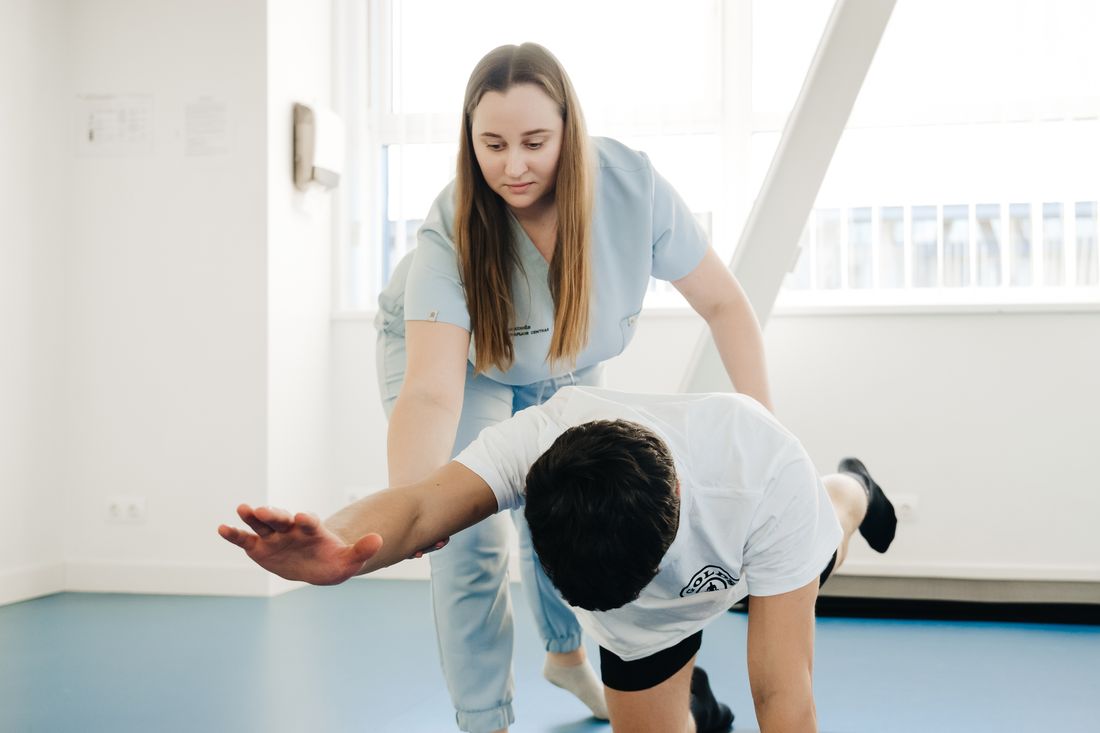 Fisioterapeuta realizando terapia manual assistindo homem durante exercício