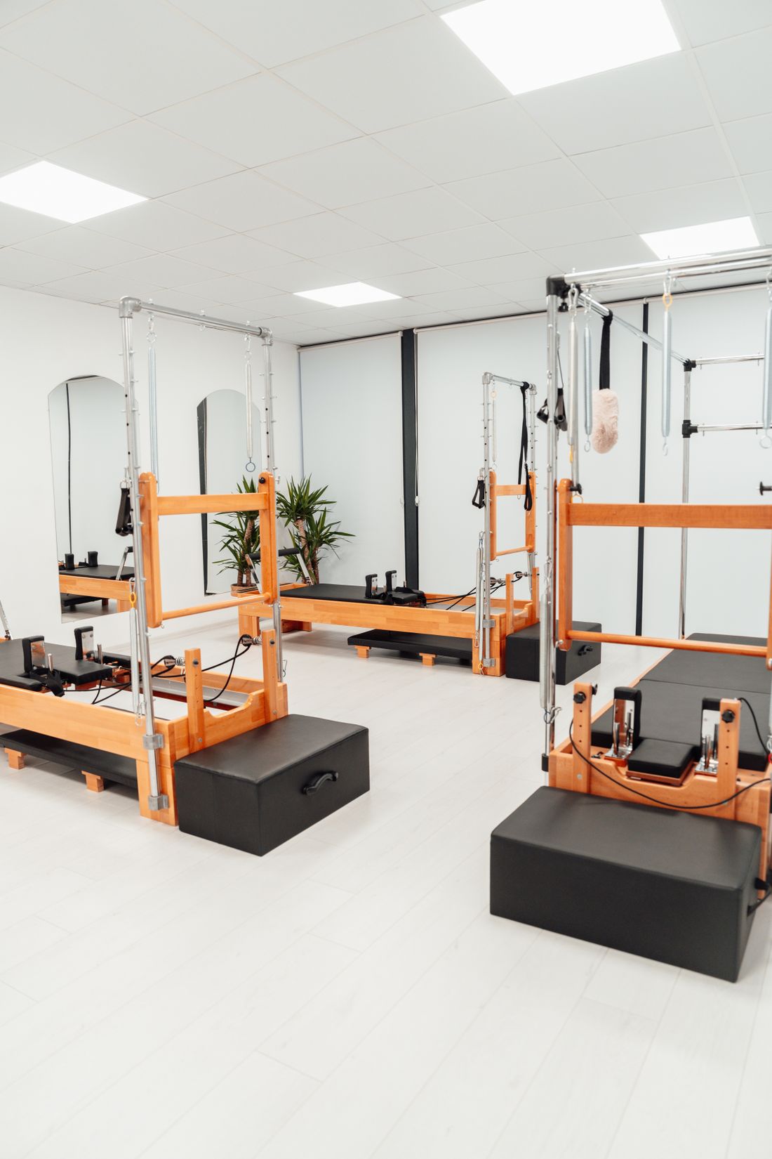 Estudio de pilates com aparelhos reformer em sala iluminada e clean