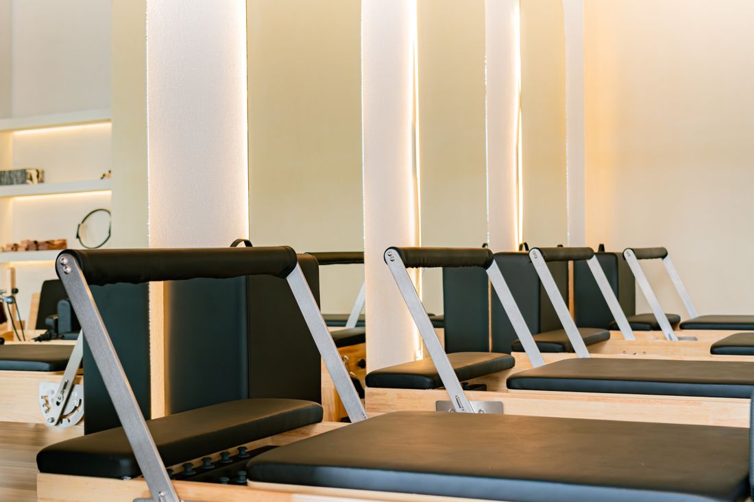 Estudio de pilates moderno com aparelhos reformer alinhados em sala clara