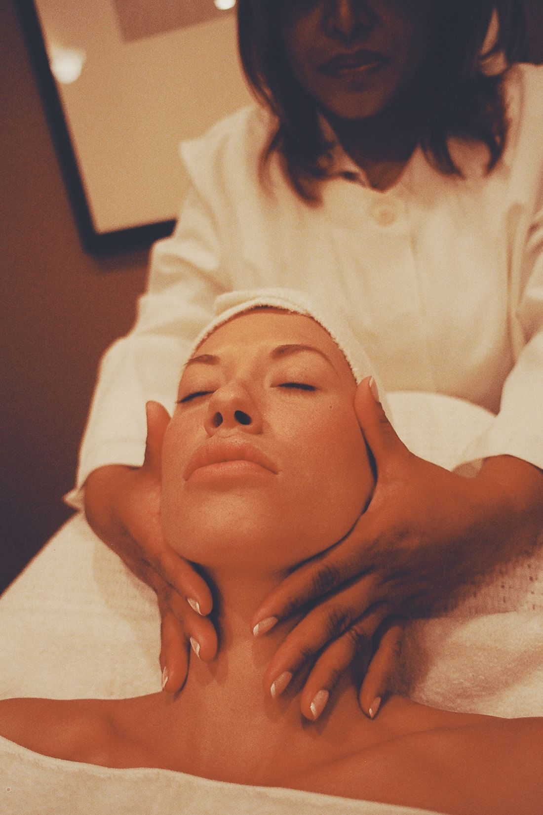 Terapia manual na regiao da mandibula e do rosto, com massagem facial relaxante em ambiente clinico