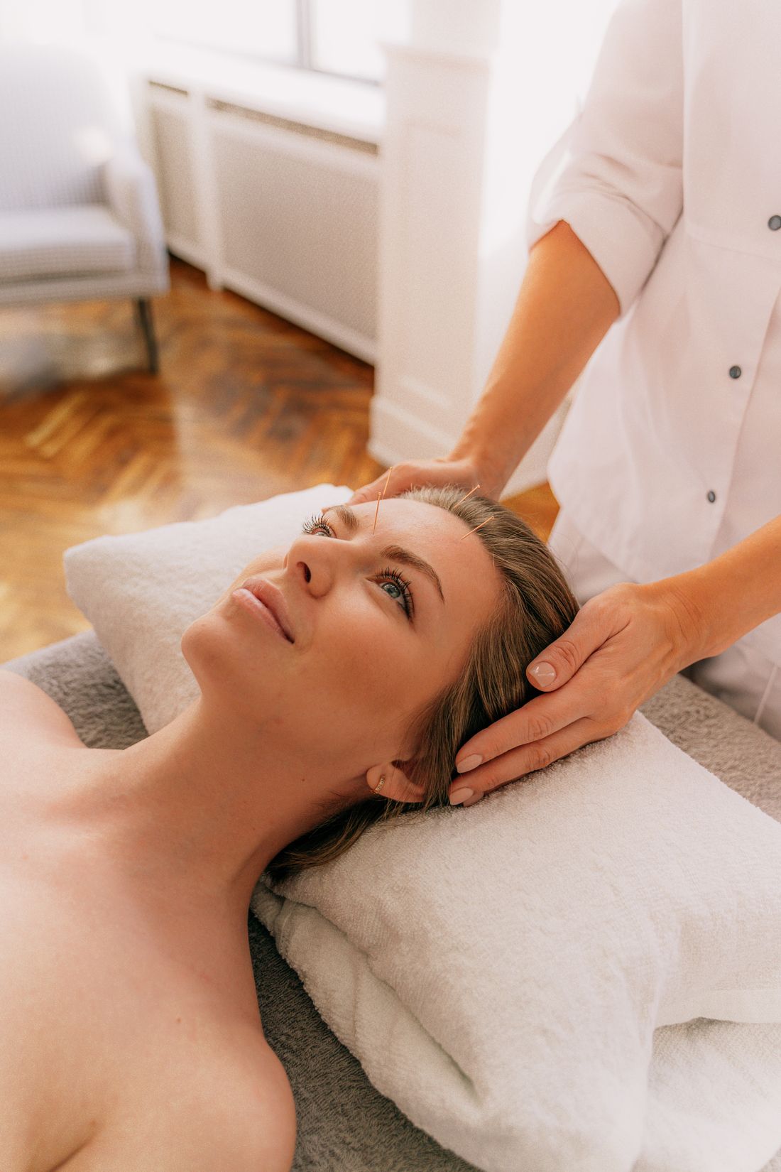Terapeuta trabalhando a musculatura facial e da mandibula da paciente com as maos