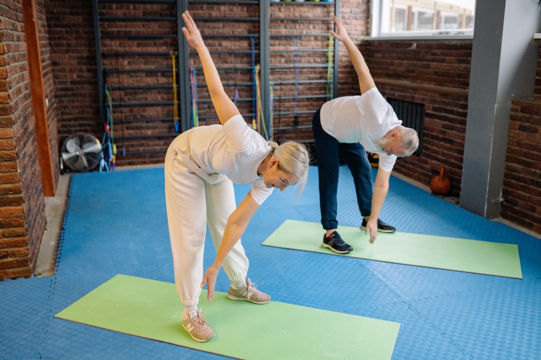 Pessoa idosa realizando alongamento em sessao de pilates