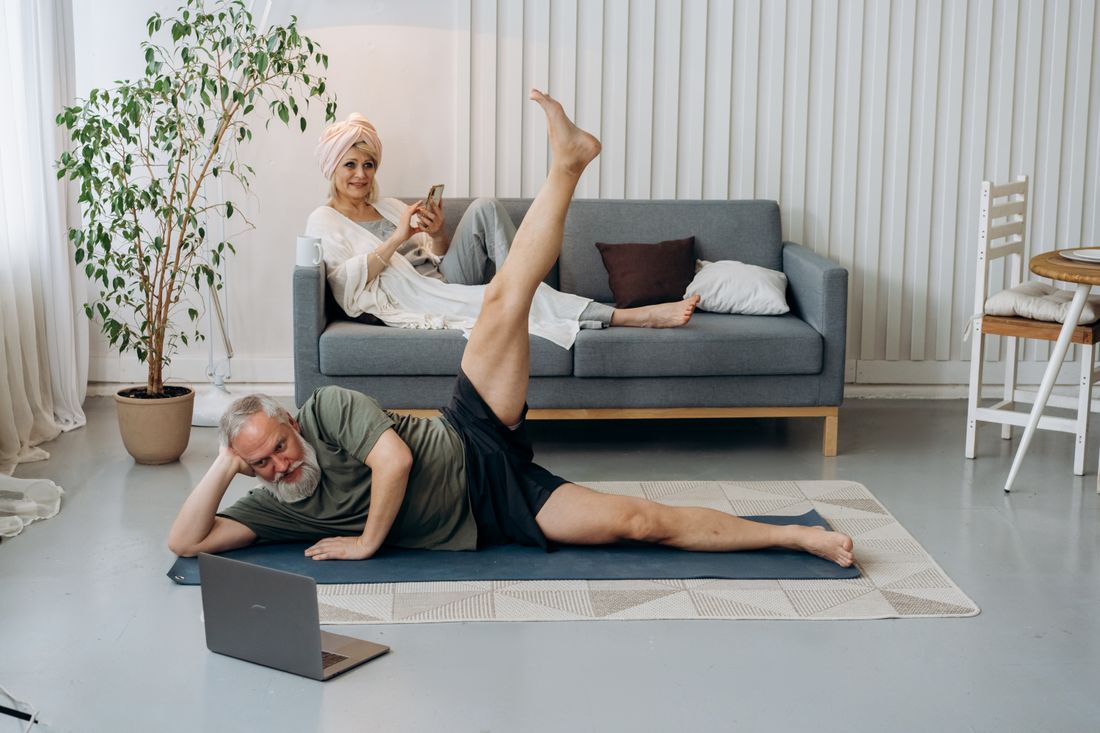 Pessoa idosa em exercicio de pilates com apoio profissional