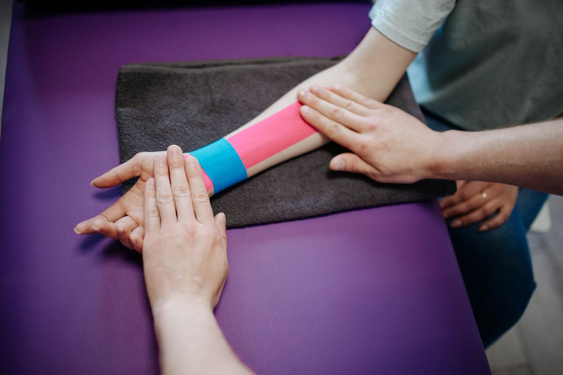 Reabilitacao em fisioterapia: aplicacao de bandagem terapeutica no antebraco do paciente