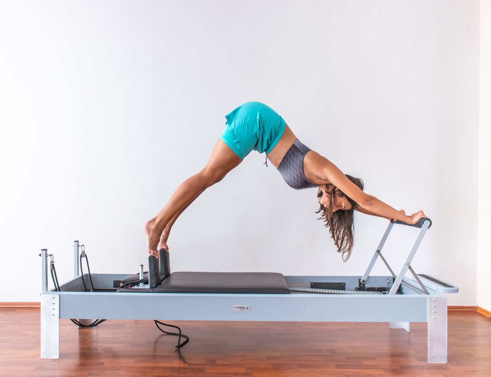 Mulher em exercício avançado no reformer de pilates